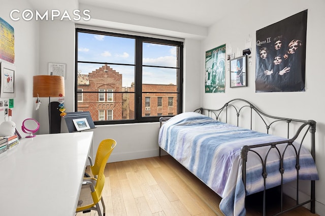 bedroom featuring wood finished floors and baseboards