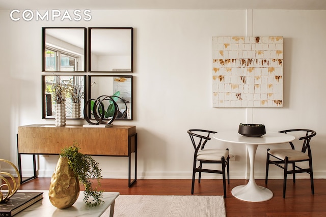 dining space featuring wood finished floors and baseboards