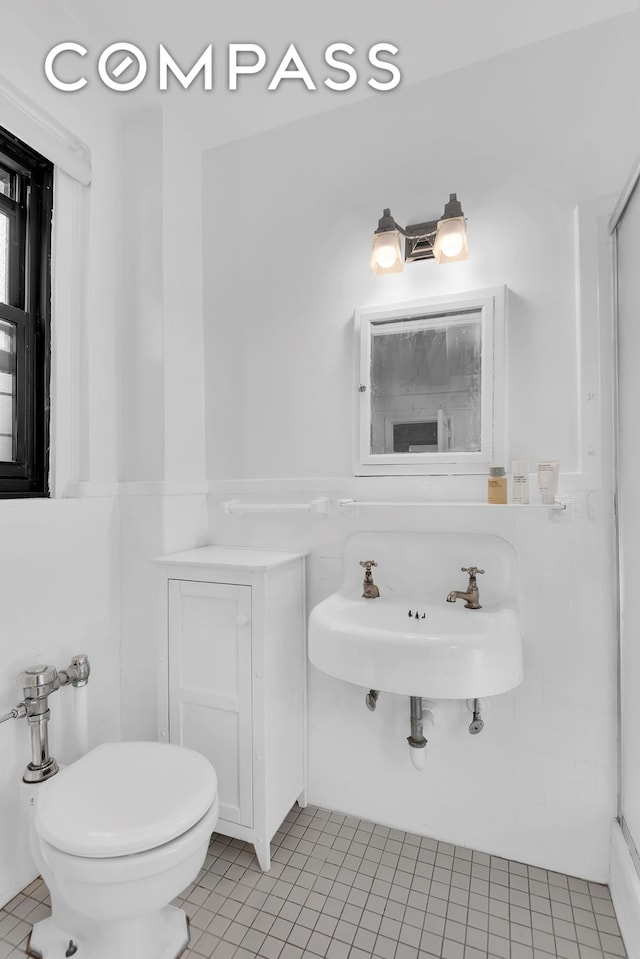 151 E 83rd St Unit 4Gh, New York City, NY 10028 - bathroom with tile patterned flooring, a sink, and toilet
