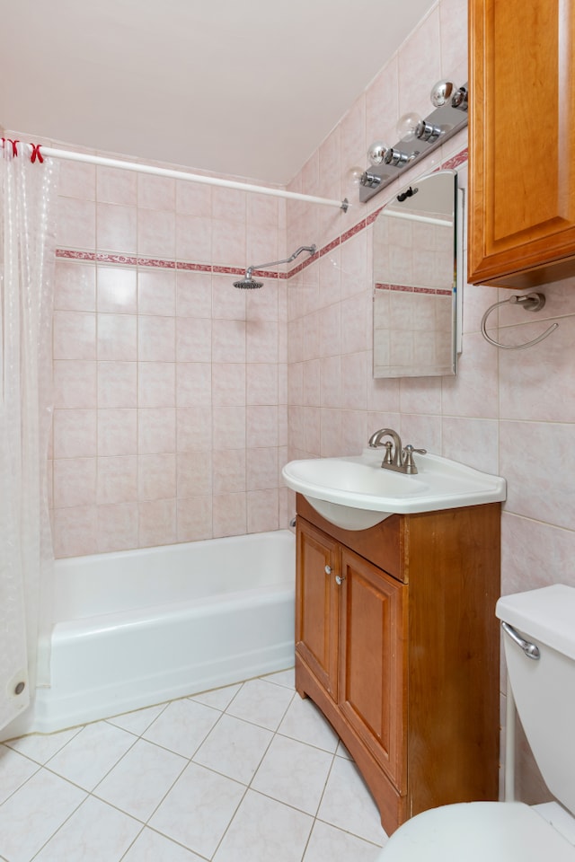full bathroom with tile walls, toilet, shower / tub combo, tile patterned floors, and vanity