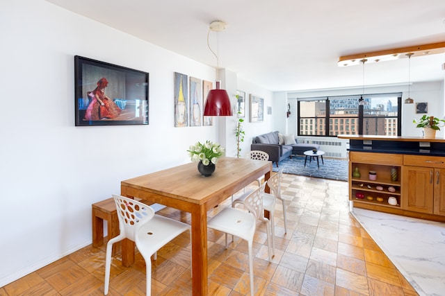 dining room featuring radiator and baseboards