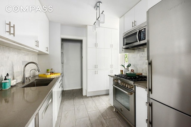 522 W End Ave Unit 2B, New York City, NY 10024 - kitchen featuring appliances with stainless steel finishes, a sink, decorative backsplash, and white cabinets