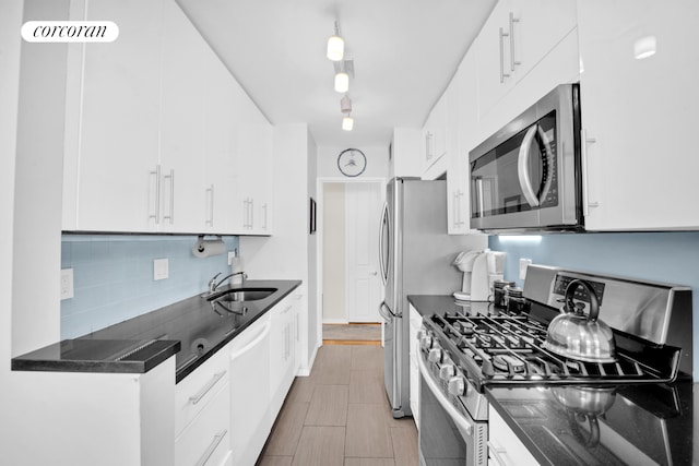 205 3rd Ave Unit 8K, New York City, NY 10003 - kitchen featuring stainless steel appliances, a sink, decorative backsplash, and white cabinetry