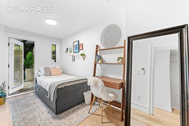 bedroom featuring access to outside and light wood finished floors