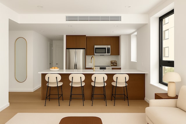 229 Withers St Unit 3C, New York City, NY 11211 - kitchen with appliances with stainless steel finishes, baseboards, a breakfast bar area, a sink, and recessed lighting