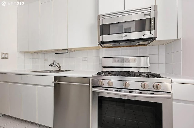63 E 9th St Unit 7-T, New York City, NY 10003 - kitchen featuring appliances with stainless steel finishes, light countertops, white cabinetry, tasteful backsplash, and modern cabinets