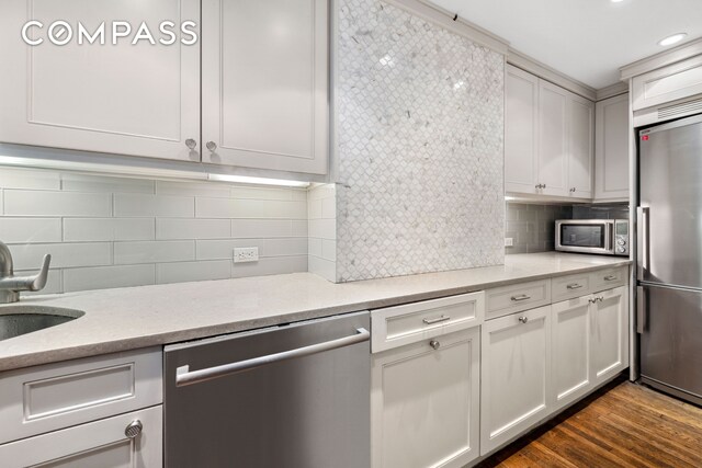 kitchen with stainless steel appliances, tasteful backsplash, white cabinetry, dark wood-style floors, and recessed lighting