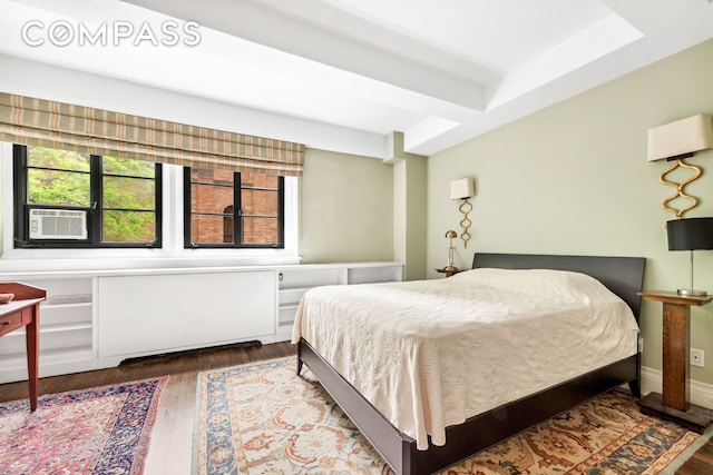 bedroom with cooling unit and wood finished floors