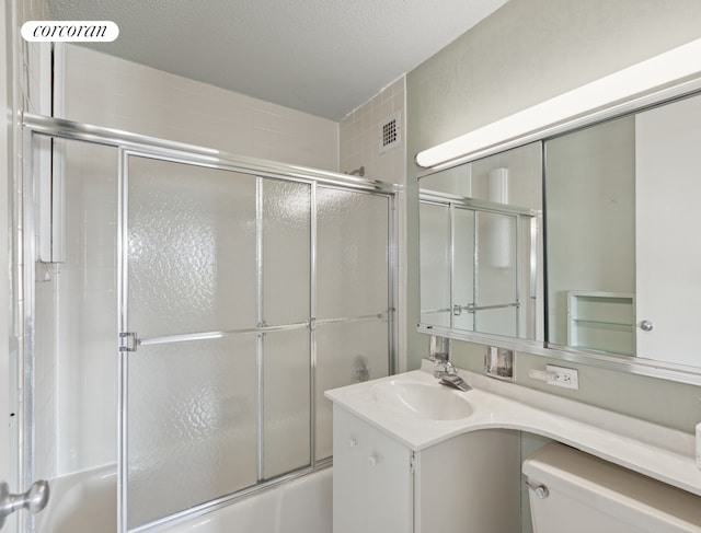 bathroom with toilet, combined bath / shower with glass door, and vanity