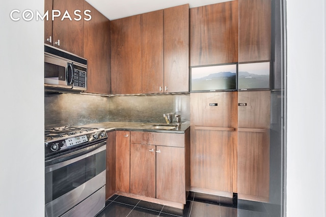 343 E 74th St Unit 15D, New York City, NY 10021 - kitchen with appliances with stainless steel finishes, a sink, backsplash, and dark tile patterned flooring