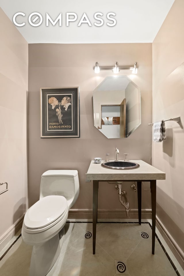 1065 Park Ave Unit 11A, New York City, NY 10128 - bathroom with a sink, toilet, baseboards, and tile patterned flooring