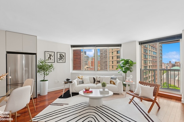 living area with a view of city, wood finished floors, and baseboards