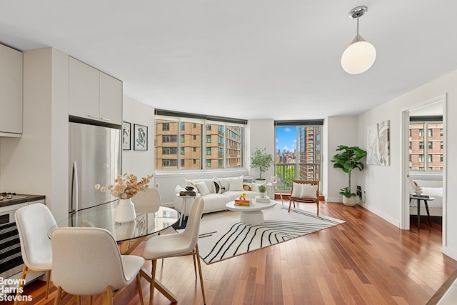 dining space featuring light wood-style flooring and baseboards