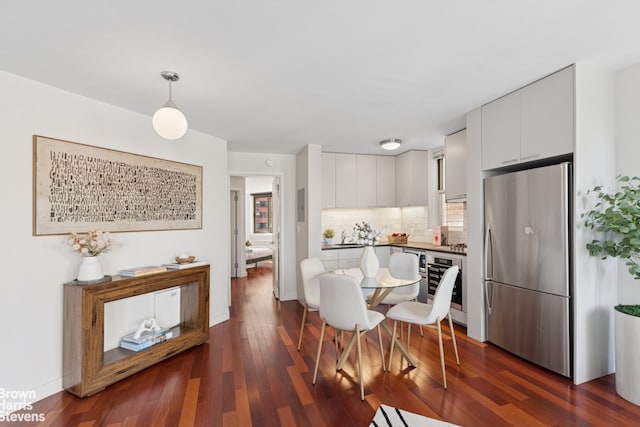 dining space with dark wood-type flooring and baseboards