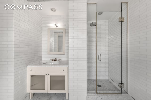 40 E 66th St Unit 12B, New York City, NY 10065 - full bathroom with vanity, a stall shower, and tile walls