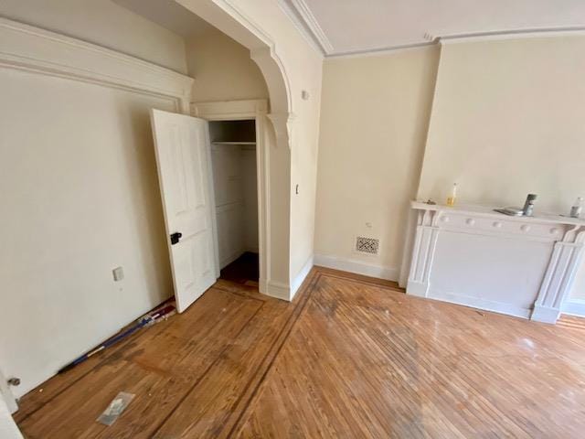 188 Mac Donough St, New York City, NY 11216 - unfurnished bedroom featuring light wood-type flooring, arched walkways, crown molding, and a closet