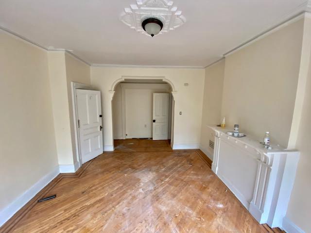 188 Mac Donough St, New York City, NY 11216 - unfurnished dining area with crown molding, arched walkways, and light wood-type flooring