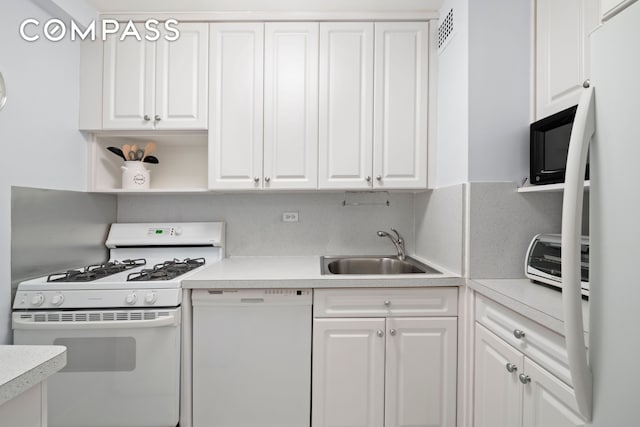 kitchen featuring white appliances, a sink, white cabinetry, light countertops, and open shelves