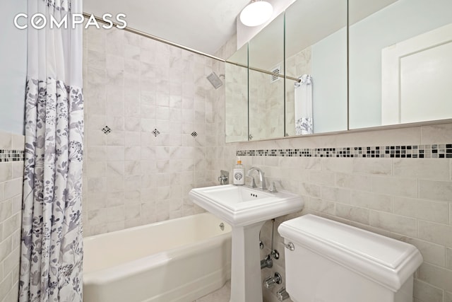 full bath featuring tile walls, shower / bath combo with shower curtain, and toilet