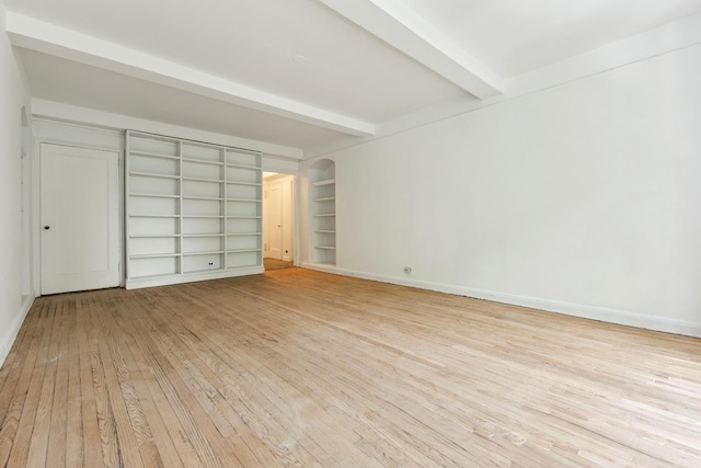 410 W 24th St Unit 4L, New York City, NY 10011 - unfurnished bedroom featuring light wood finished floors, beamed ceiling, and baseboards