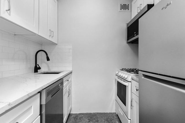 410 W 24th St Unit 4L, New York City, NY 10011 - kitchen with stainless steel appliances, a sink, backsplash, and white cabinetry