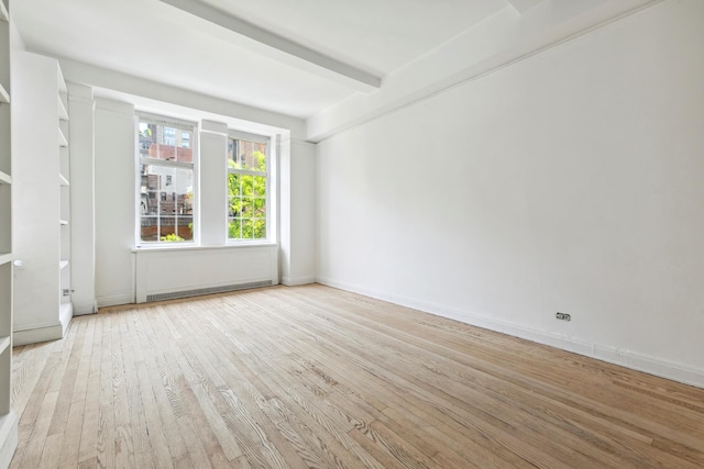 spare room with hardwood / wood-style flooring, beamed ceiling, baseboards, and a baseboard radiator