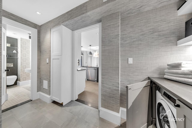 laundry room with light tile patterned floors, washer / clothes dryer, and baseboards