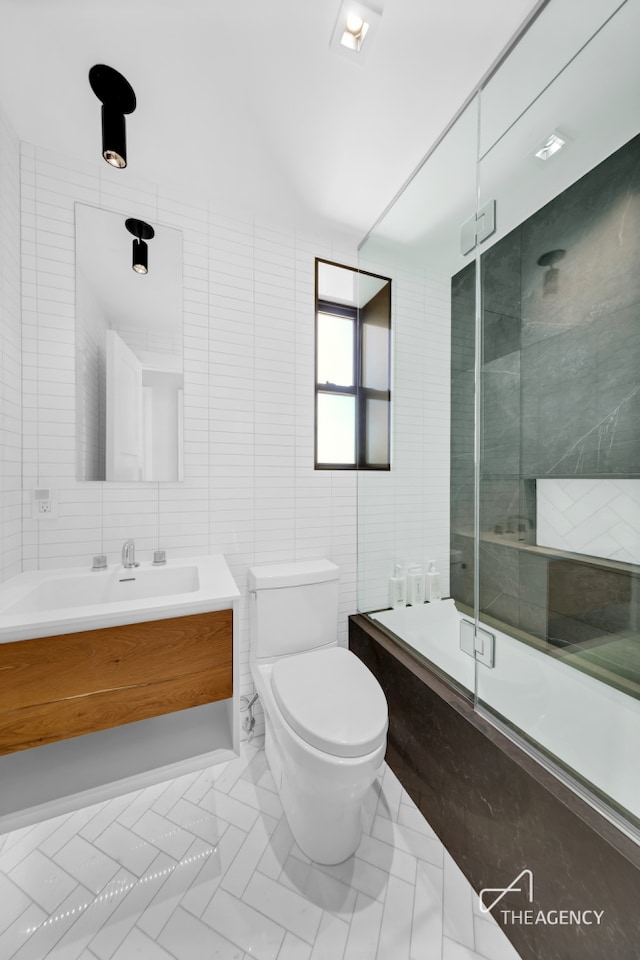 bathroom featuring tile walls, toilet, and vanity