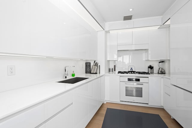 400 Park Ave S Unit 23-B, New York City, NY 10016 - kitchen featuring white oven, modern cabinets, white cabinets, gas cooktop, and recessed lighting