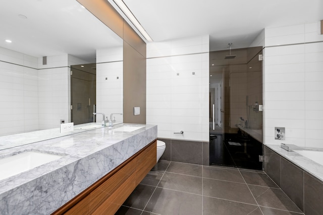 400 Park Ave S Unit 23-B, New York City, NY 10016 - full bath with tile patterned flooring, double vanity, a stall shower, a relaxing tiled tub, and toilet