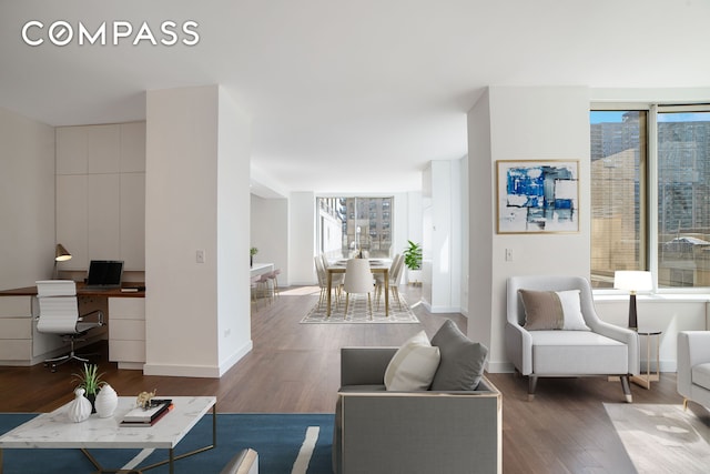 living room with an office area, wood finished floors, and baseboards