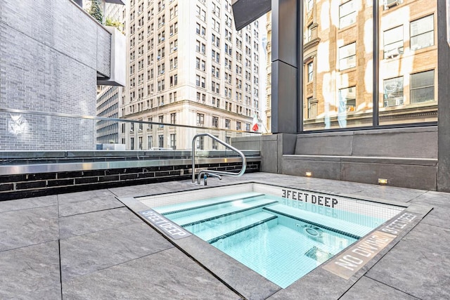 view of swimming pool featuring a hot tub