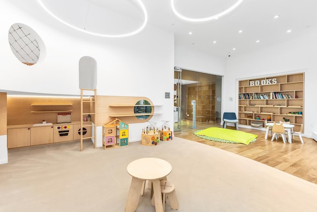 recreation room with recessed lighting and a towering ceiling