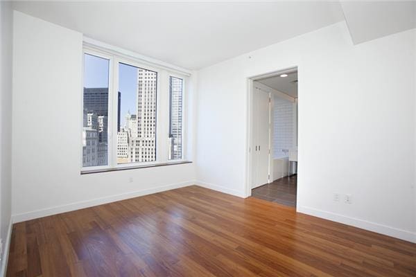 unfurnished room featuring wood finished floors and baseboards