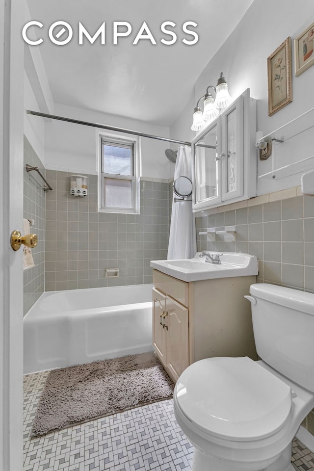 full bathroom with toilet, shower / tub combo, vanity, tile walls, and tile patterned floors