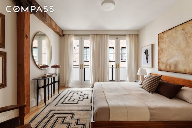 bedroom with access to outside, wood finished floors, and french doors