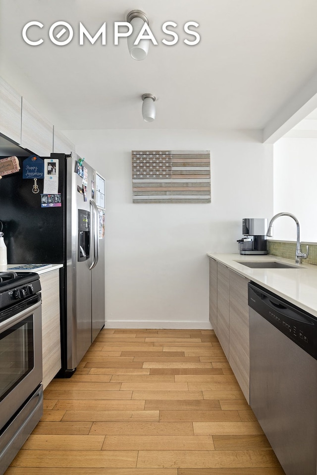91-16 Shore Front Pkwy Unit 2F, New York City, NY 11693 - kitchen with stainless steel appliances, a sink, modern cabinets, and light wood finished floors