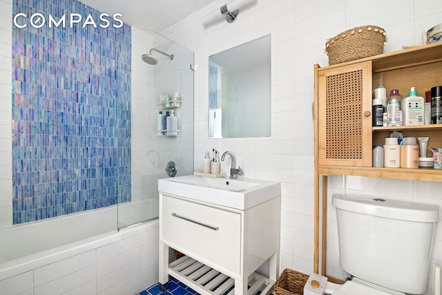 91-16 Shore Front Pkwy Unit 2F, New York City, NY 11693 - full bathroom featuring tile walls, tiled shower / bath combo, vanity, and toilet