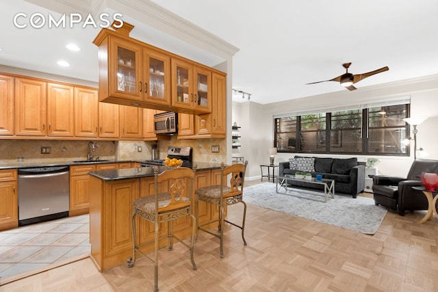 kitchen featuring stainless steel appliances, a ceiling fan, a sink, tasteful backsplash, and recessed lighting