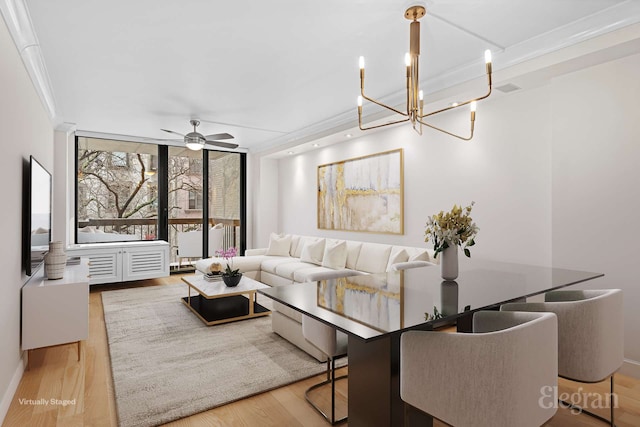 living room with wood finished floors, floor to ceiling windows, a ceiling fan, ornamental molding, and a chandelier