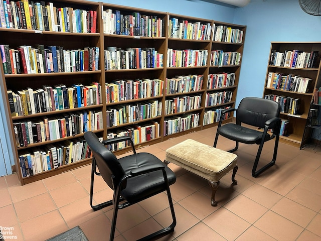living area featuring bookshelves and tile patterned floors