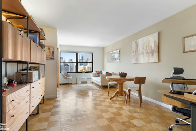 dining area featuring baseboards and an office area