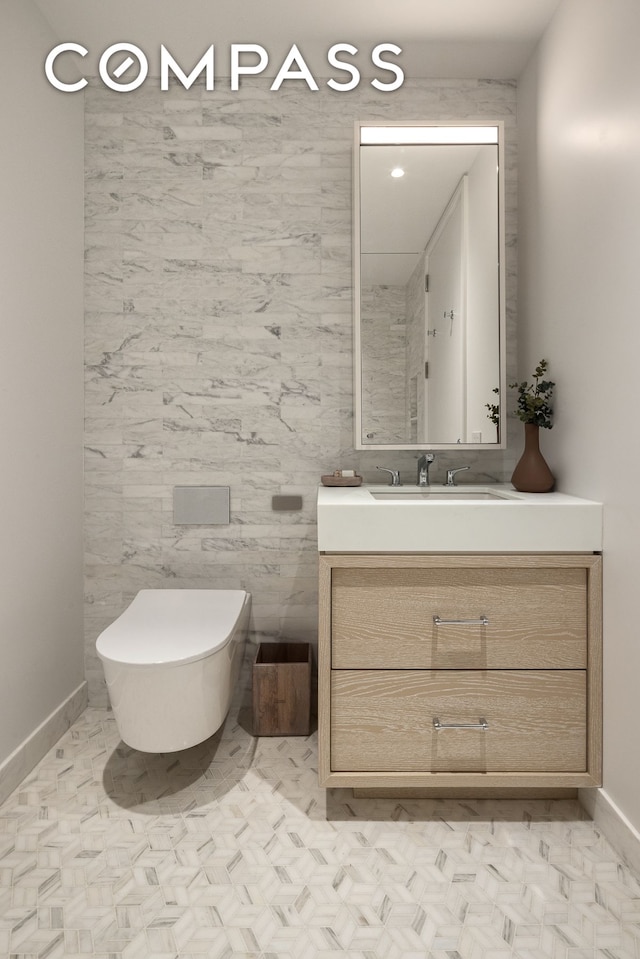 bathroom featuring vanity, baseboards, and toilet