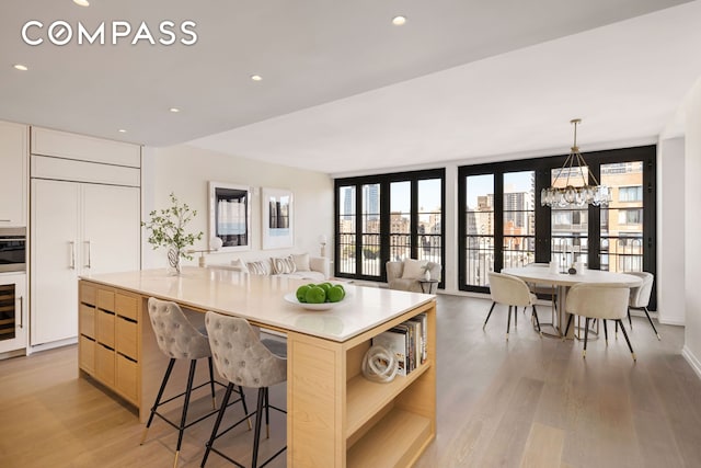 250 W 96th St Unit 11E, New York City, NY 10025 - kitchen with modern cabinets, light wood-type flooring, light countertops, a chandelier, and open shelves