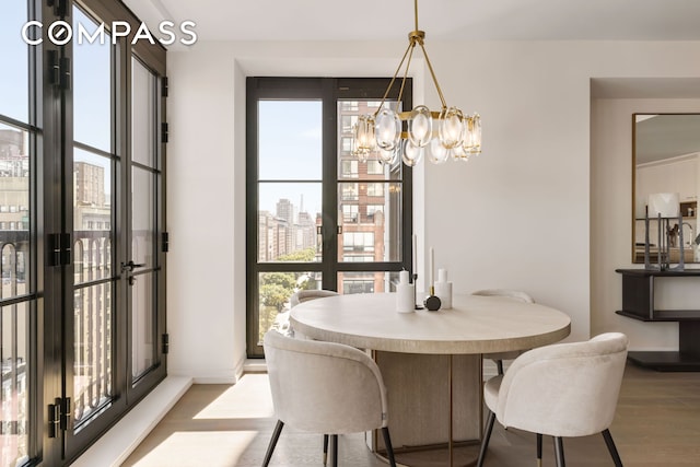 dining area with a chandelier, wood finished floors, plenty of natural light, and baseboards