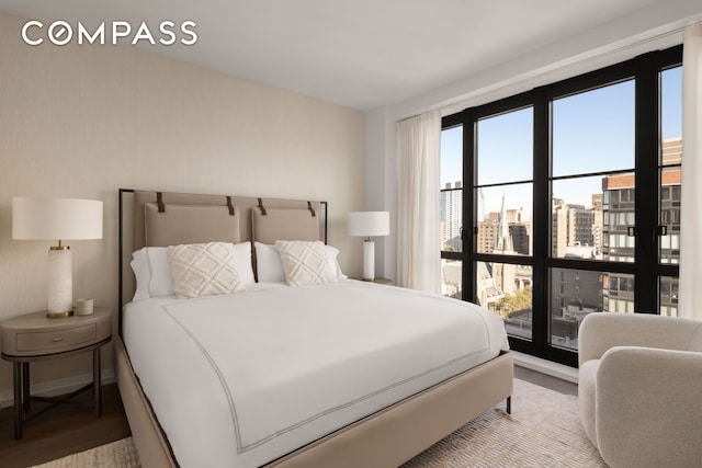 250 W 96th St Unit 11E, New York City, NY 10025 - bedroom featuring wood finished floors, a city view, and baseboards