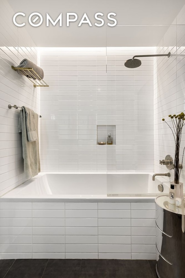 bathroom with tiled shower / bath combo and tile patterned flooring