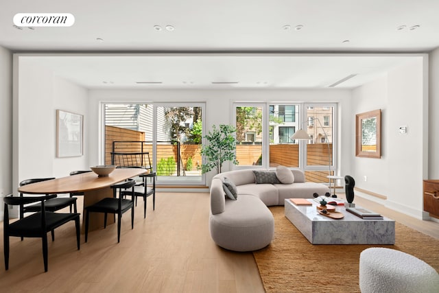 living area with light wood-style flooring, baseboards, and recessed lighting