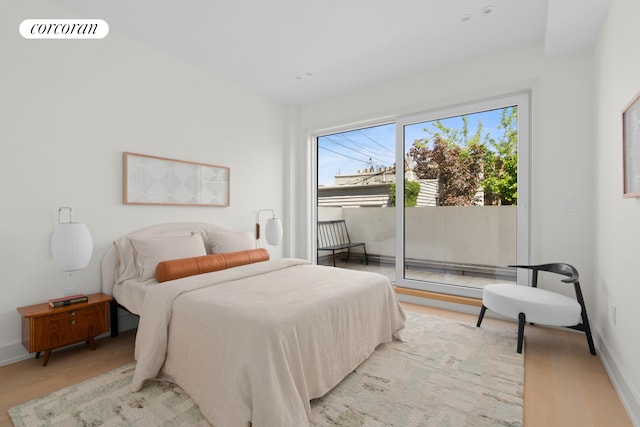 bedroom with light wood-style flooring, access to outside, and baseboards