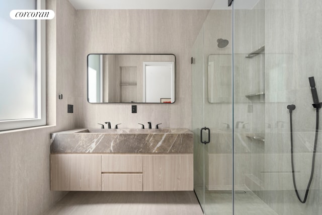 full bath with a stall shower and double vanity